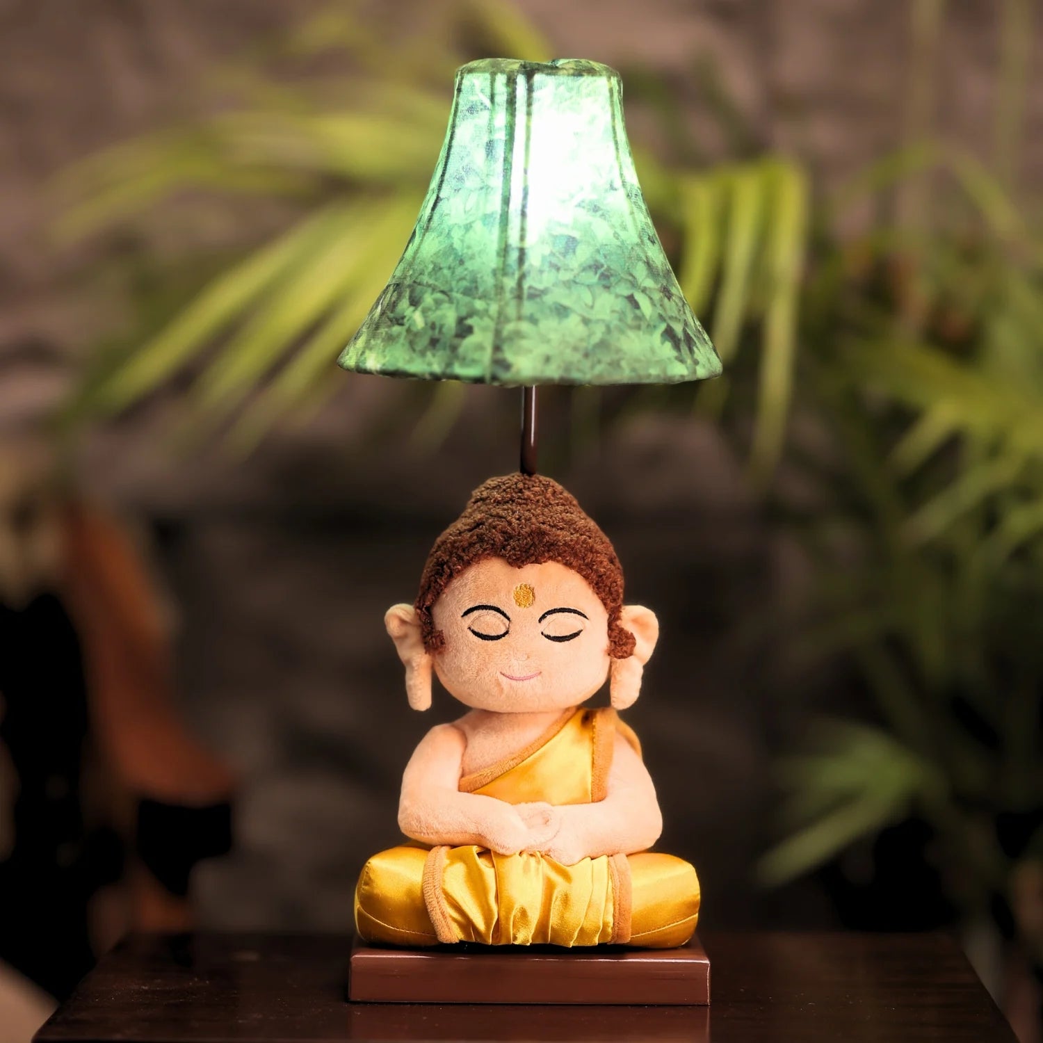 Buddha statue with a green lampshade on a blurred natural background